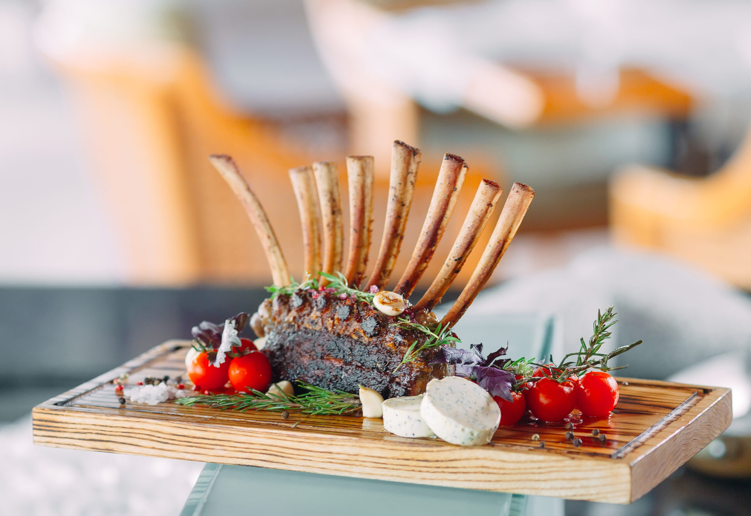 Dish Rack of Lamb with tomatoes on a wooden tray